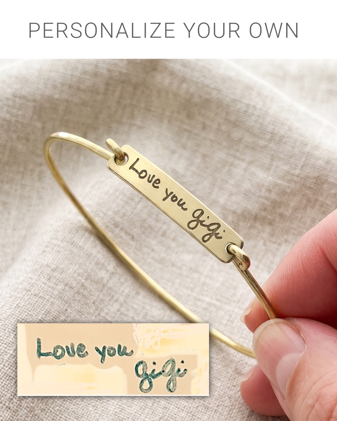 A brass bangle bracelet with a rectangular bar engraved with 'Love you Gigi' is held by a hand over a beige linen background. Text at the top reads 'PERSONALIZE YOUR OWN' and a small inset shows the engraved design on a cream card.