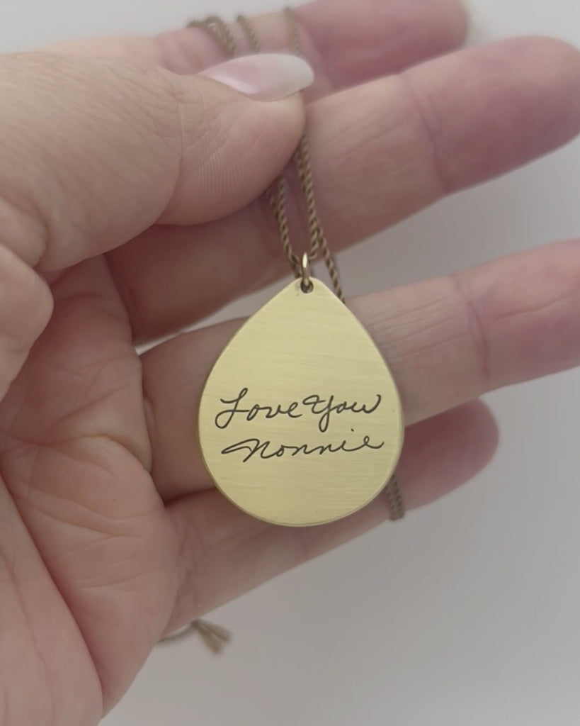 Gold tone teardrop pendant engraved with Nonnie's handwriting. Modeled and moving. 