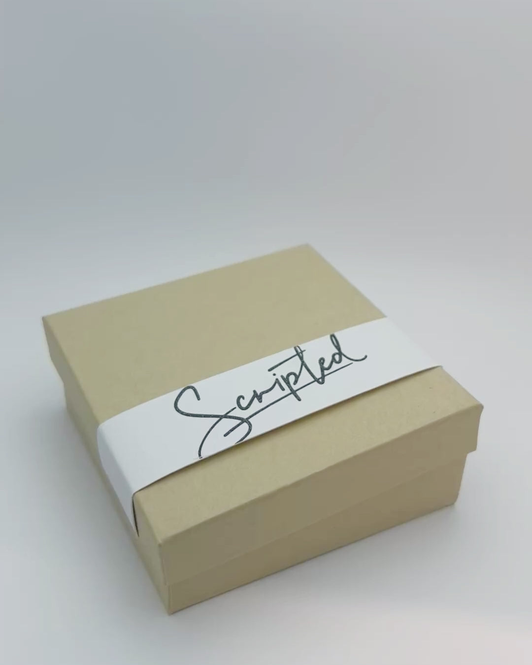 Opening packaging to reveal silver bracelet engraved with handwritten message. 