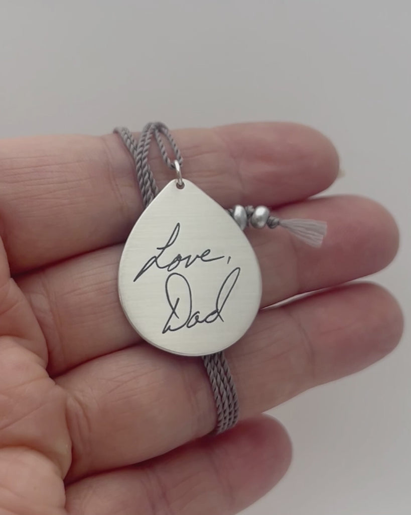 Silver teardrop pendant engraved with handwriting. Modeled and moving. 