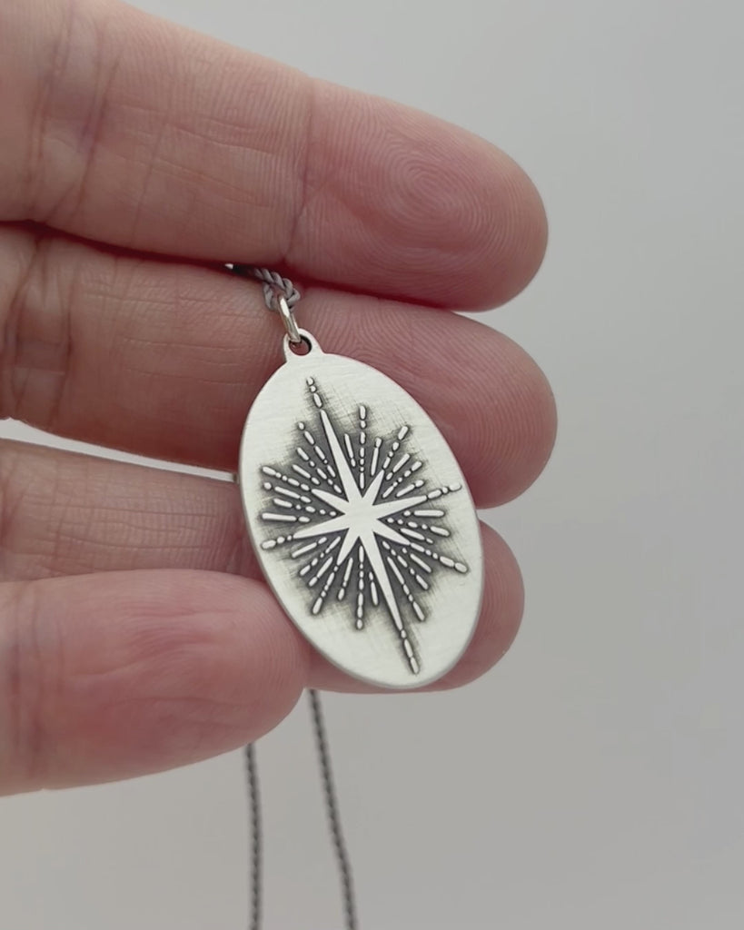 Silver pendant engraved with sparkly star motif. 