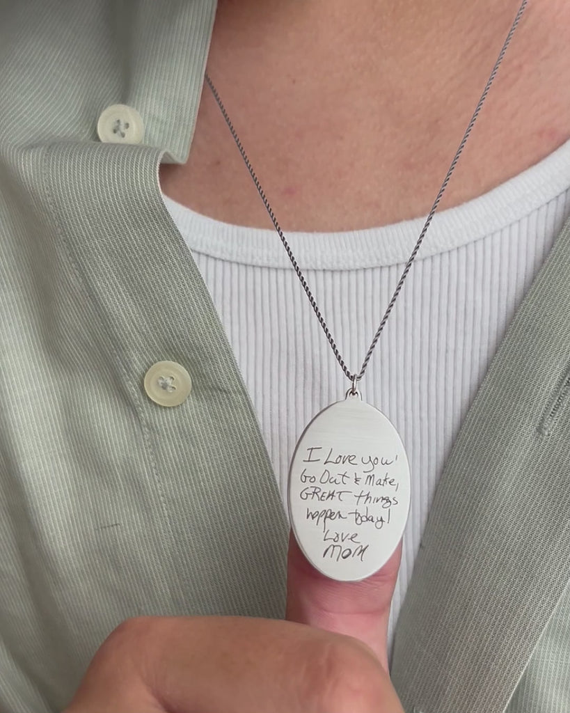 Signature engraved oval pendant in sterling silver. Moving and modeled.